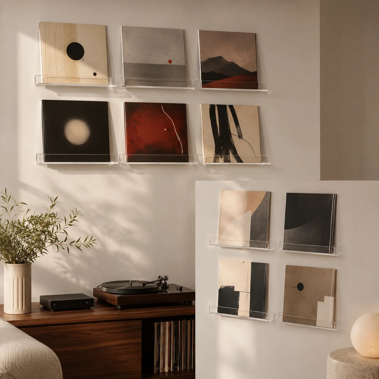 Salon avec présentoirs acryliques muraux, pochettes vinyles abstraites, platine, lampe bauhaus, coin écoute
